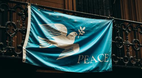 a blue flag which has a dove and says peace.