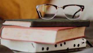 A photo of some glasses on a pile of books