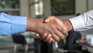 2 people shaking hands. 