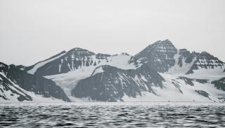 snowy mountains infront of water 