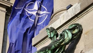 NATO flag behind a statue