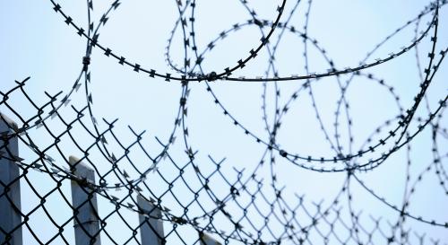 A zoomed in photograph showing barbed wire on a border fence