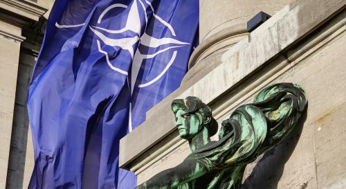 NATO flag behind a statue