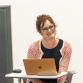 Ruth Blakeley giving a lecture from behind a laptop